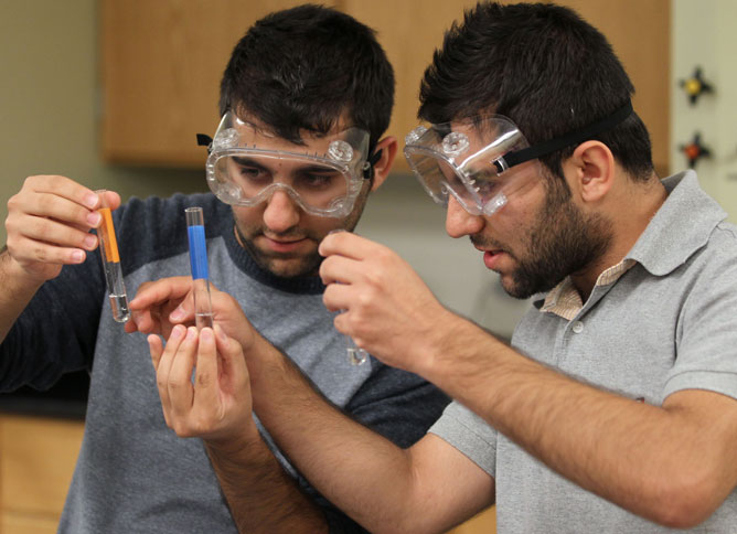 Two students comparing test tubes.