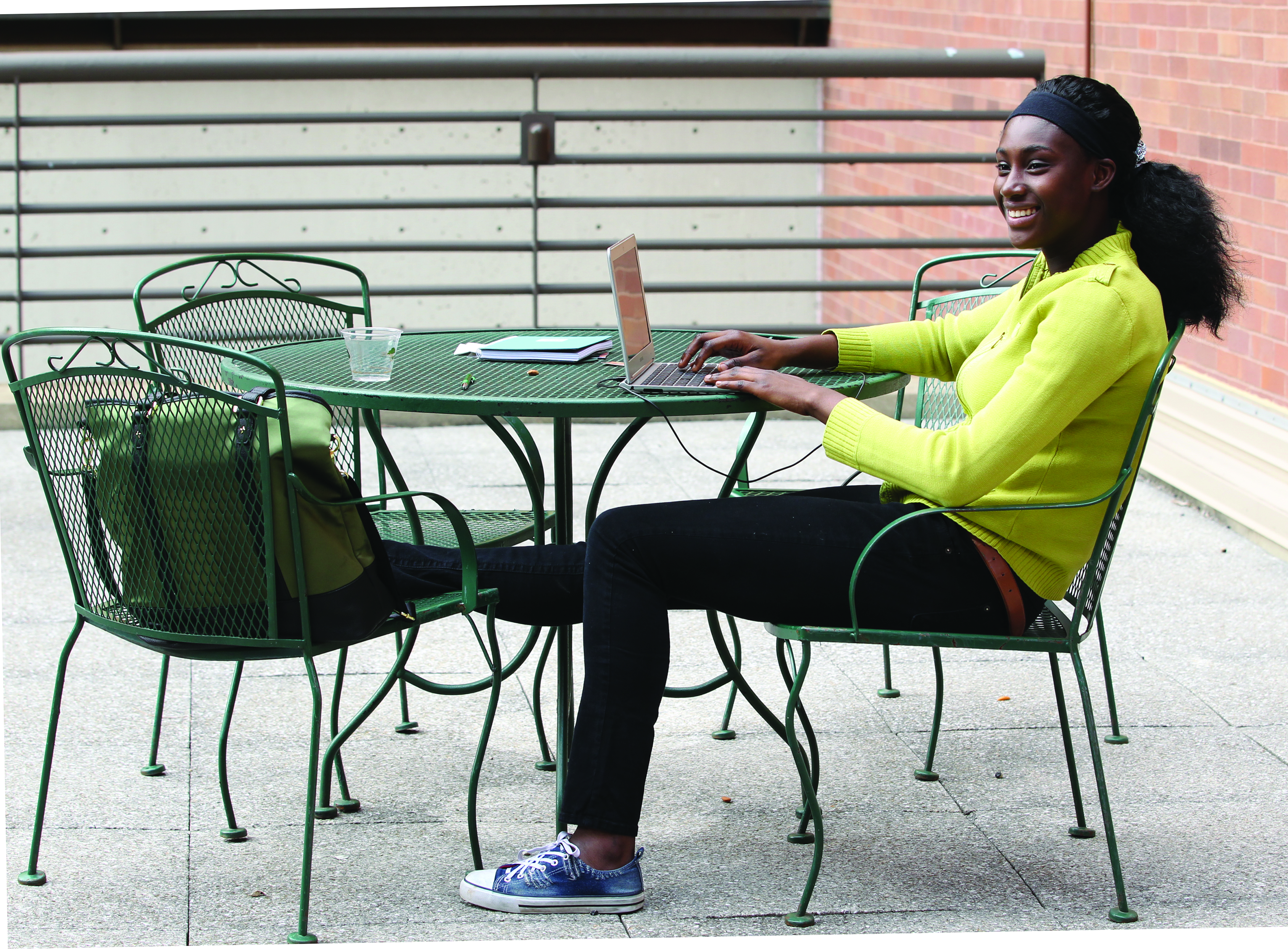 Student sitting at a table outdoors.