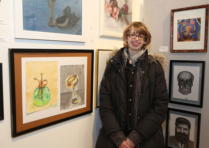 Oakton student displaying artwork at student show.