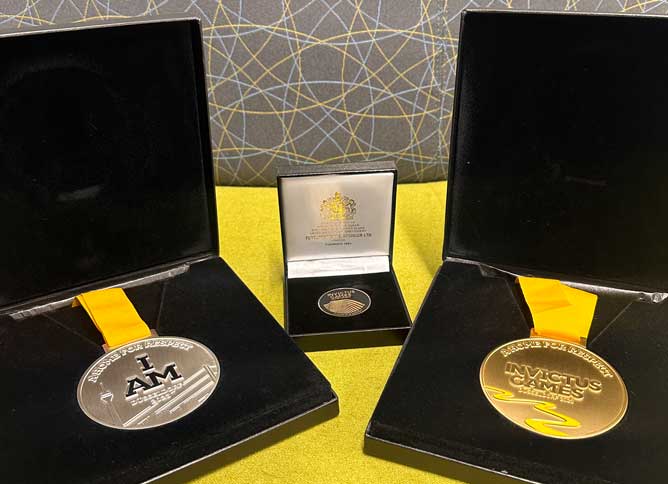 Two Invictus Games medals on a table.